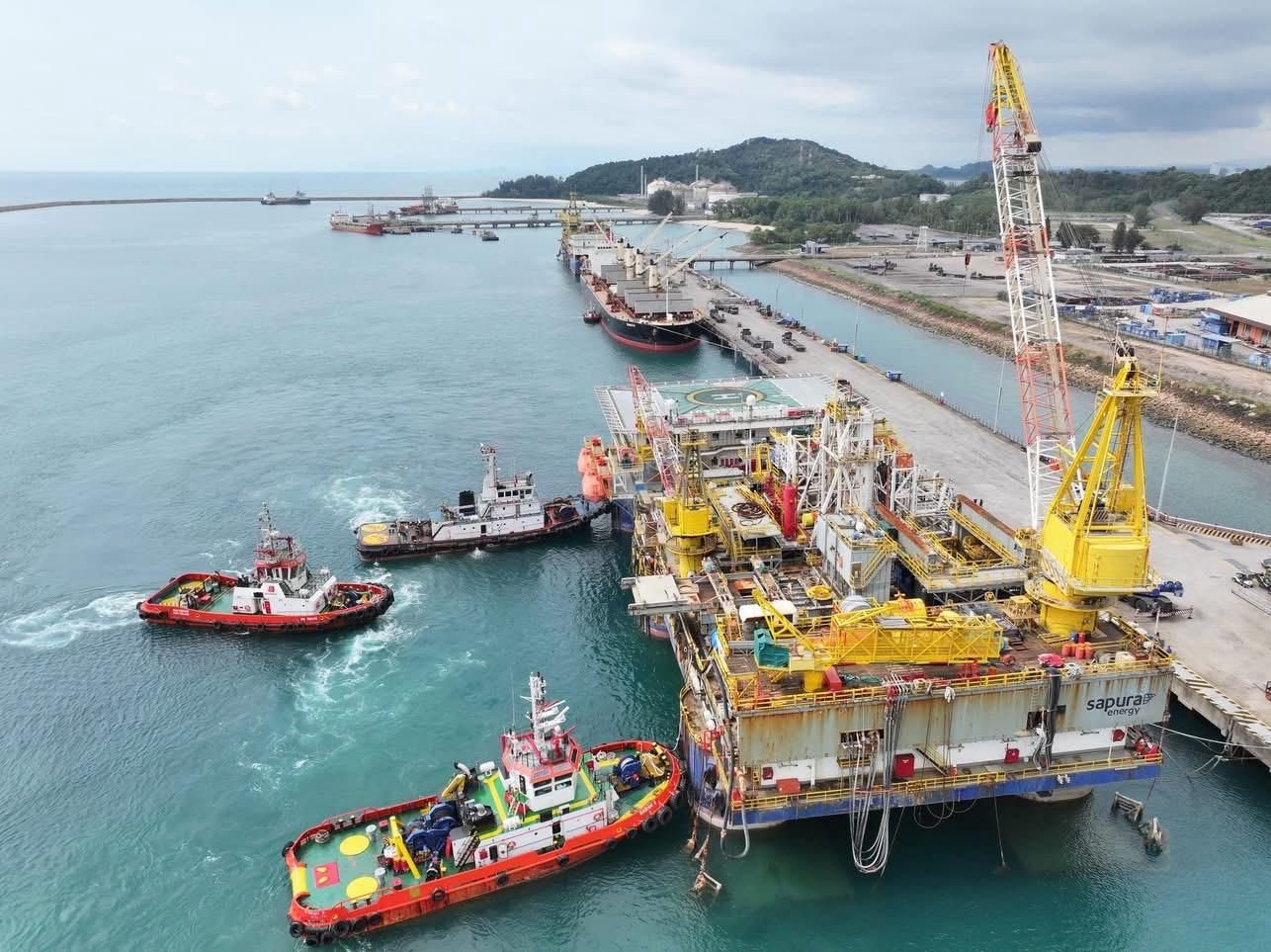Tugs manoeuvring a tender assisted drilling rig alongside a quay