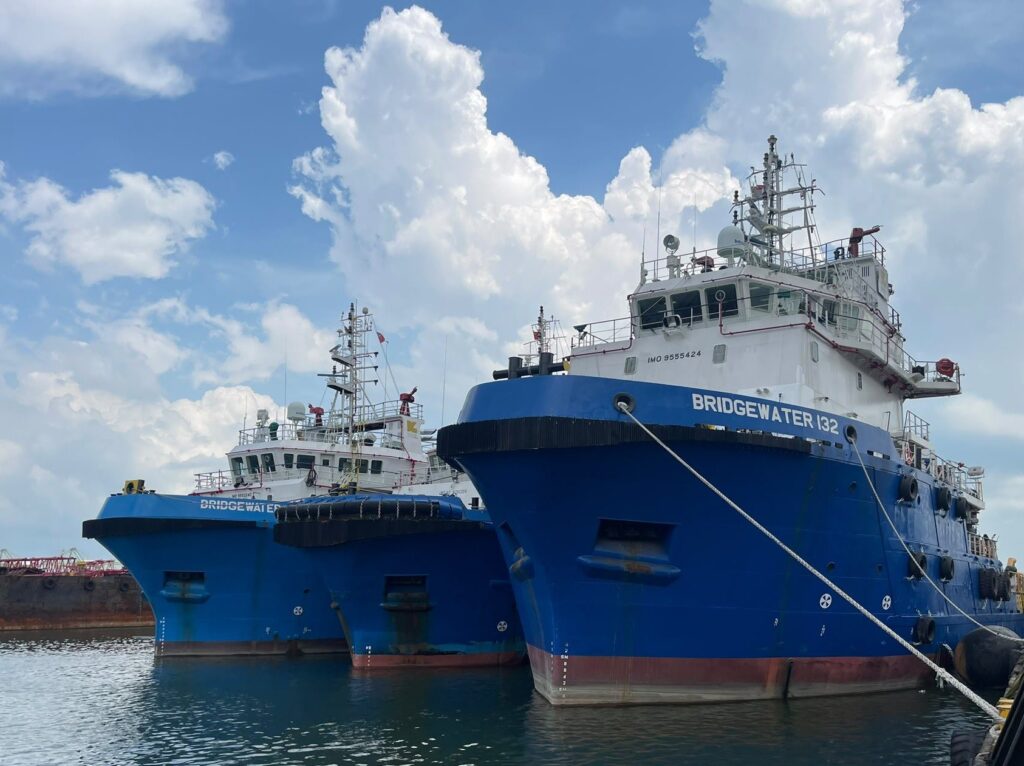 Three blue offshore support vessels, including Bridgewater 132, moored alongside a quay